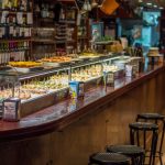 Balcão de bar espanhol com uma variedade de tapas e pinchos expostos para servir.