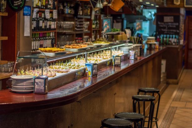 Balcão de bar espanhol com uma variedade de tapas e pinchos expostos para servir.
