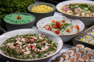 Variedade de pratos da culinária japonesa, incluindo sushis e saladas, dispostos sobre uma mesa.